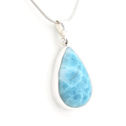A teardrop-shaped Larimar pendant necklace with a polished silver bezel and a silver snake chain, shown on a clean white background.