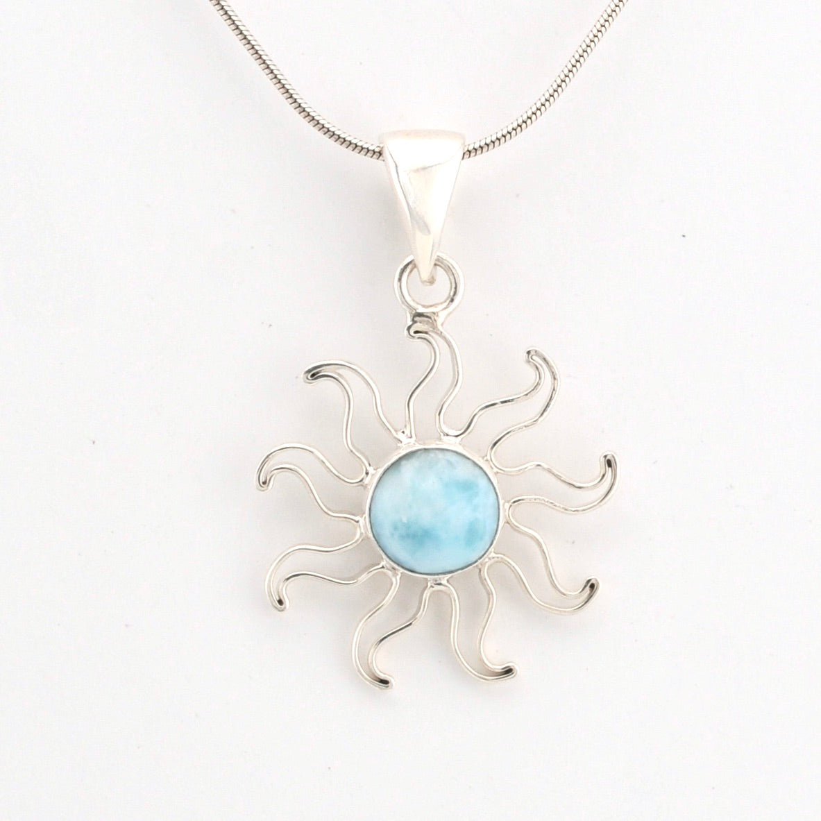Silver sun-shaped pendant with a light blue center on a white background