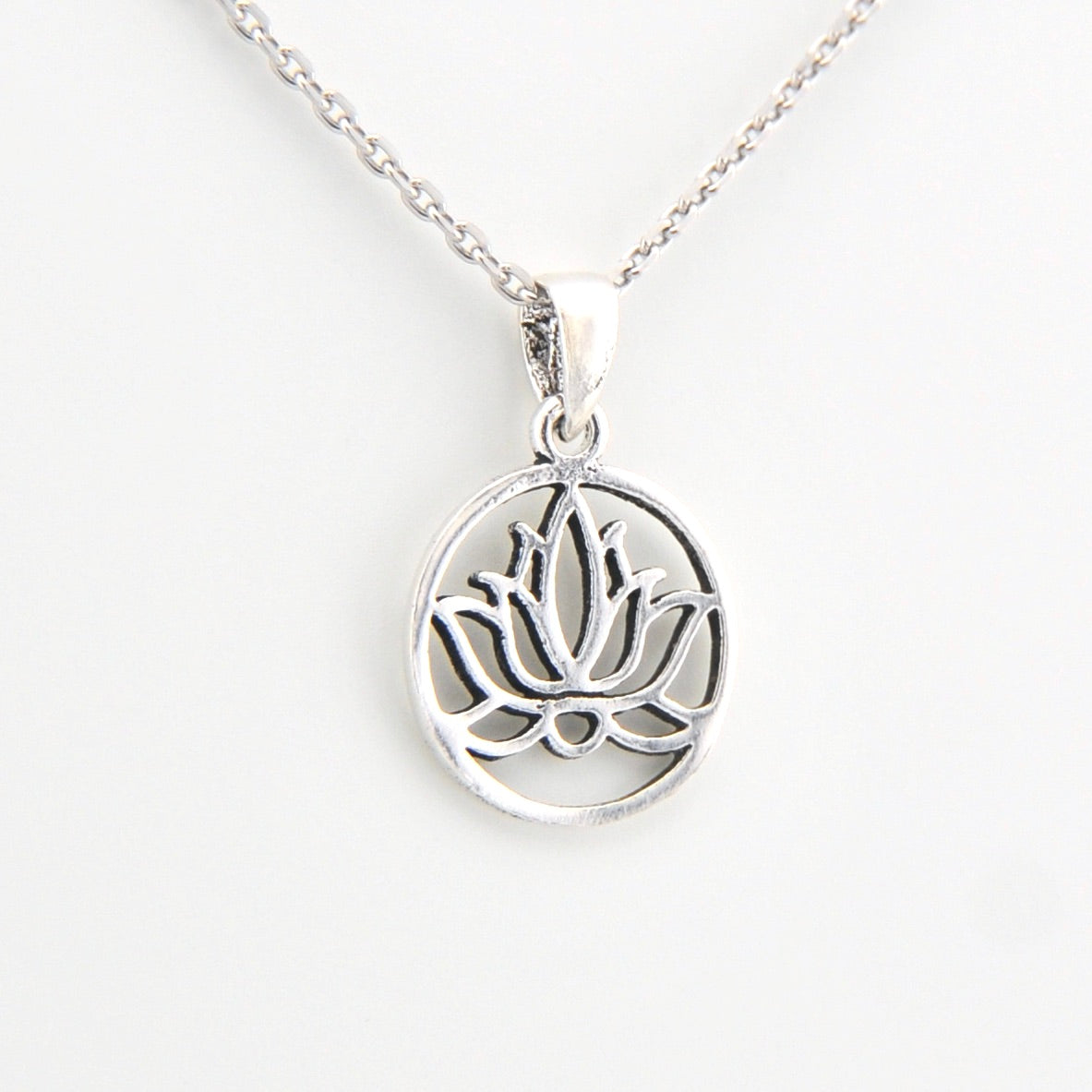 Silver lotus flower pendant on a white background