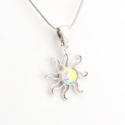 Silver sun-shaped pendant with a yellow gemstone on a white background