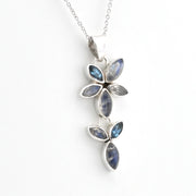 A silver pendant necklace featuring three vertical clusters of marquise-cut blue iridescent gemstones in silver settings, suspended from a delicate silver chain against a plain white background.
