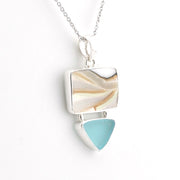A silver pendant necklace featuring a rectangular shell inlay with natural beige and cream swirls, and a dangling light blue triangular stone below, shown on a white background.