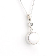 A silver necklace featuring a large, smooth white circular pendant and a smaller clear gemstone accent above it, shown on a plain white background.