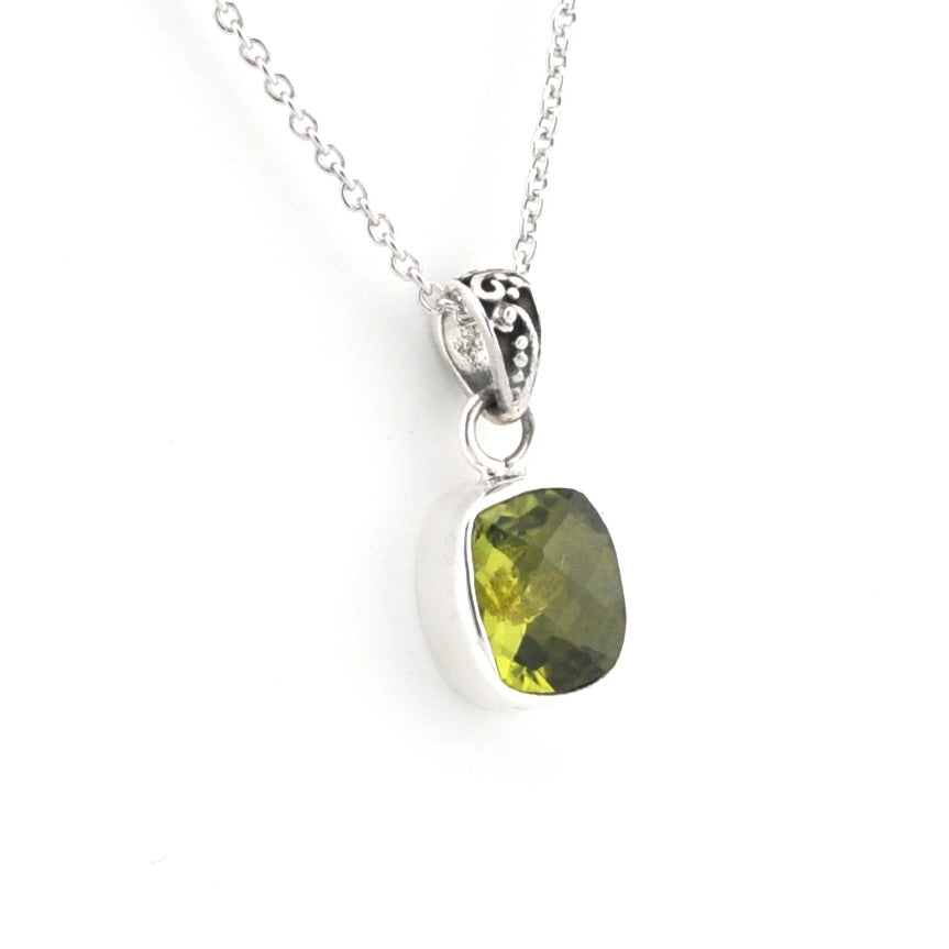 A silver pendant necklace featuring a cushion-cut olive green gemstone in a silver bezel setting, suspended from a delicate silver chain against a plain white background.