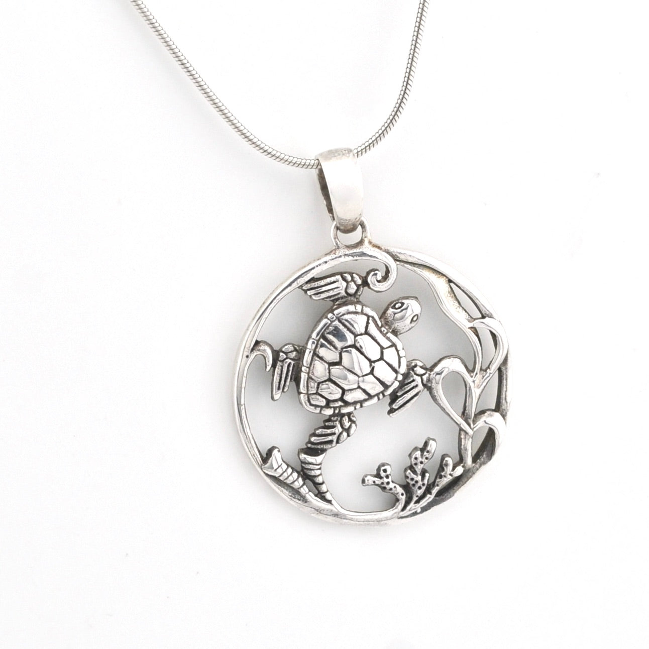 Silver turtle pendant necklace on a white background