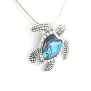 Silver turtle pendant with abalone shell on a white background