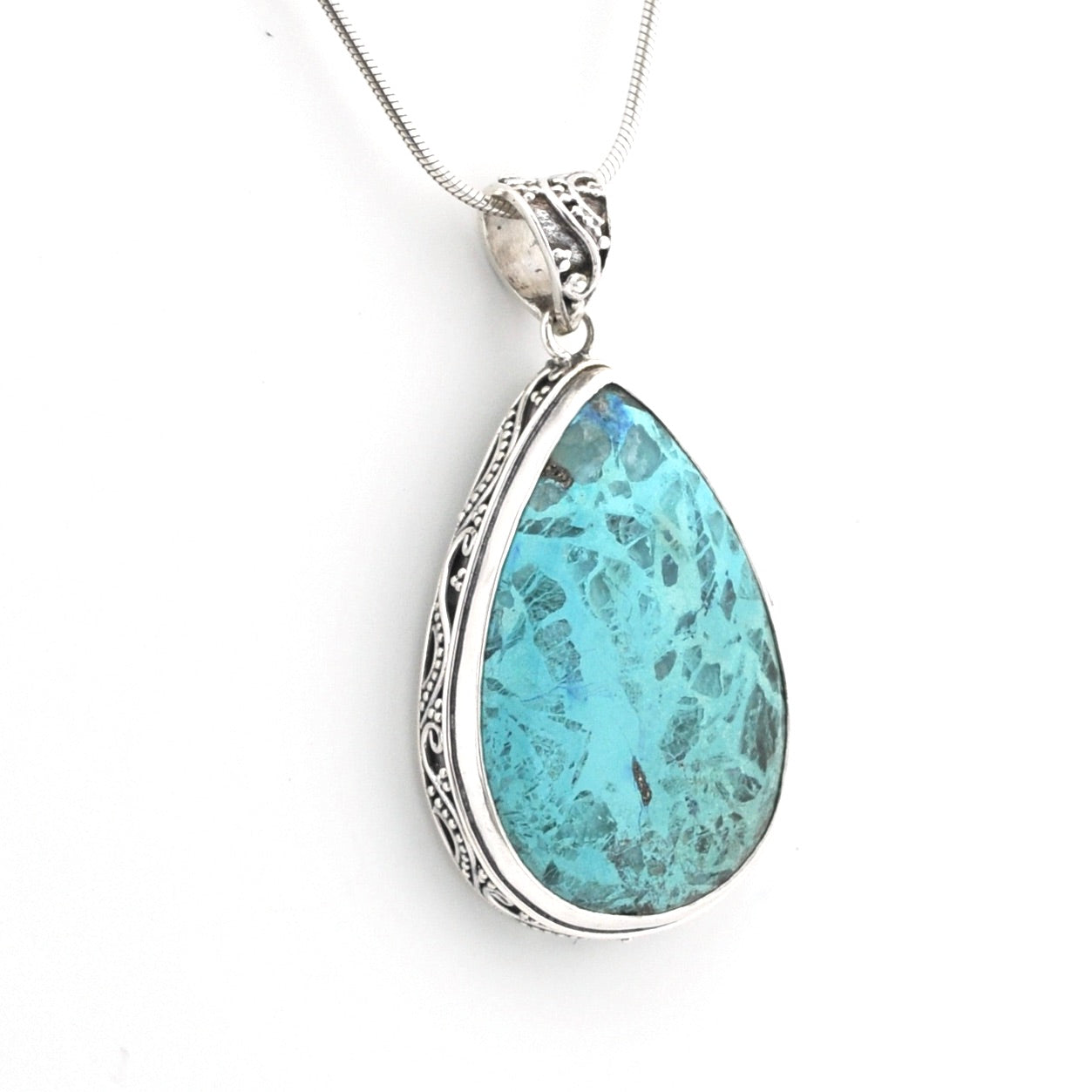 A silver teardrop pendant necklace featuring a marbled turquoise-blue stone with dark veining, set in an ornate silver bezel and suspended from a silver chain against a white background.