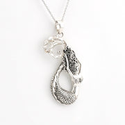 A silver mermaid pendant necklace with detailed scales and hair, shown on a white background.