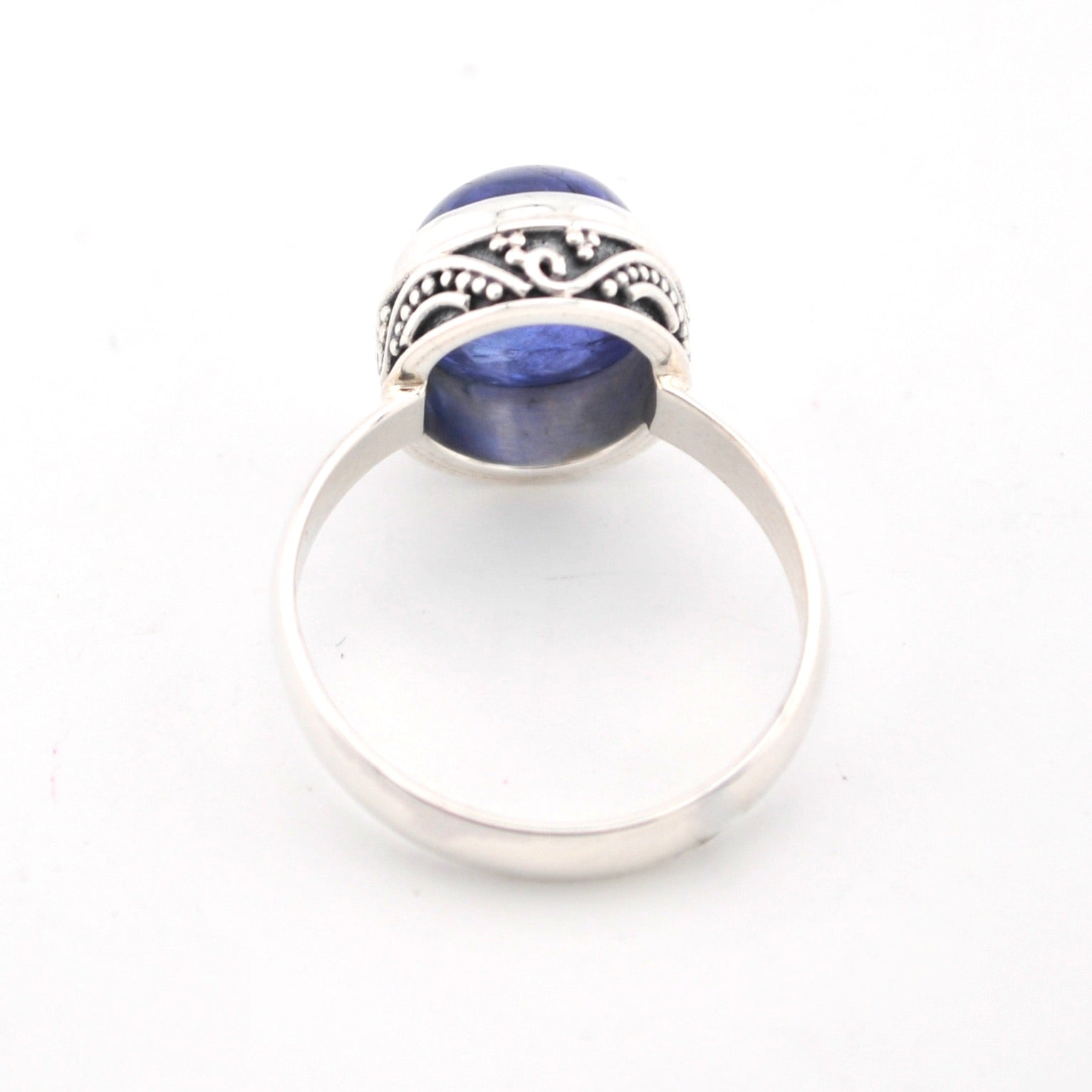 Silver ring with blue stone on a white background