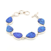 Silver bracelet with blue teardrop-shaped stones on a white background