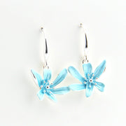 Pair of light blue flower-shaped earrings on a white background