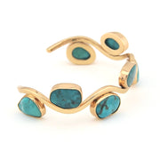 Gold bracelet with turquoise stones on a white background