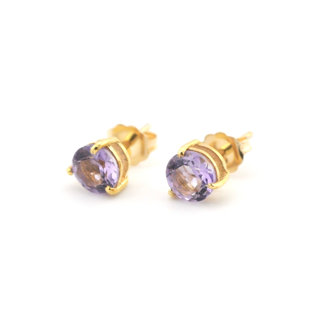 Gold stud earrings with purple gemstones on a white background