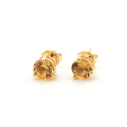 Pair of gold stud earrings with clear gemstones on a white background