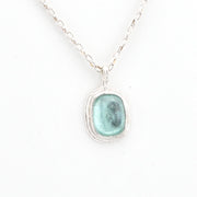Necklace with a pendant featuring a aqua Roman glass on a white background