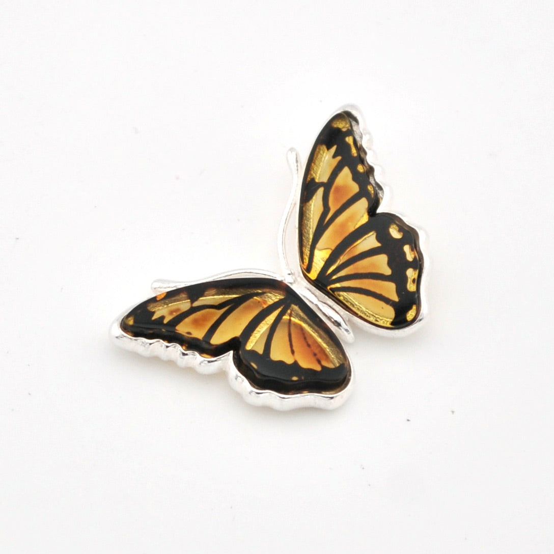 Butterfly-shaped earring with gold and black wings on a white background