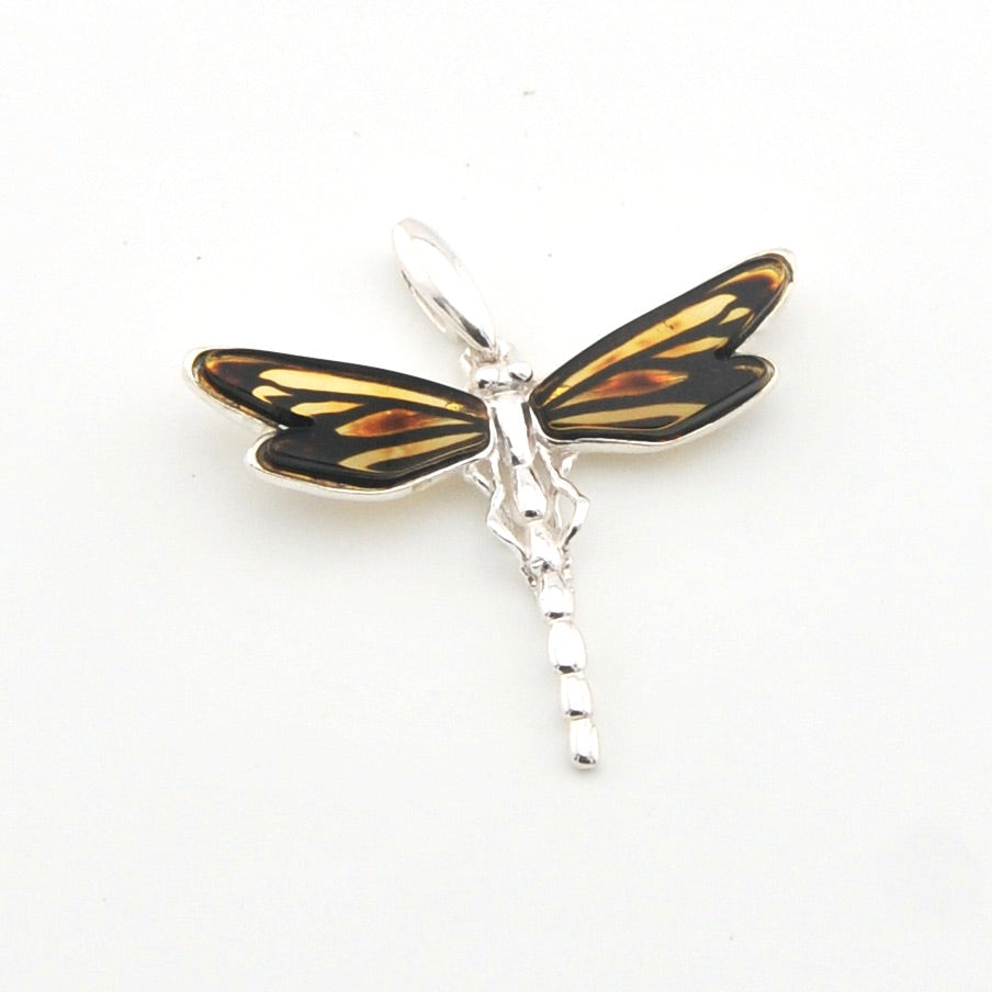 Dragonfly pendant with black and gold wings on a white background