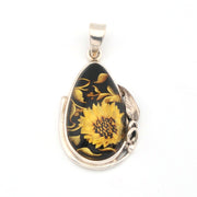 Teardrop-shaped pendant with sunflower design on a black background, set against a white background.