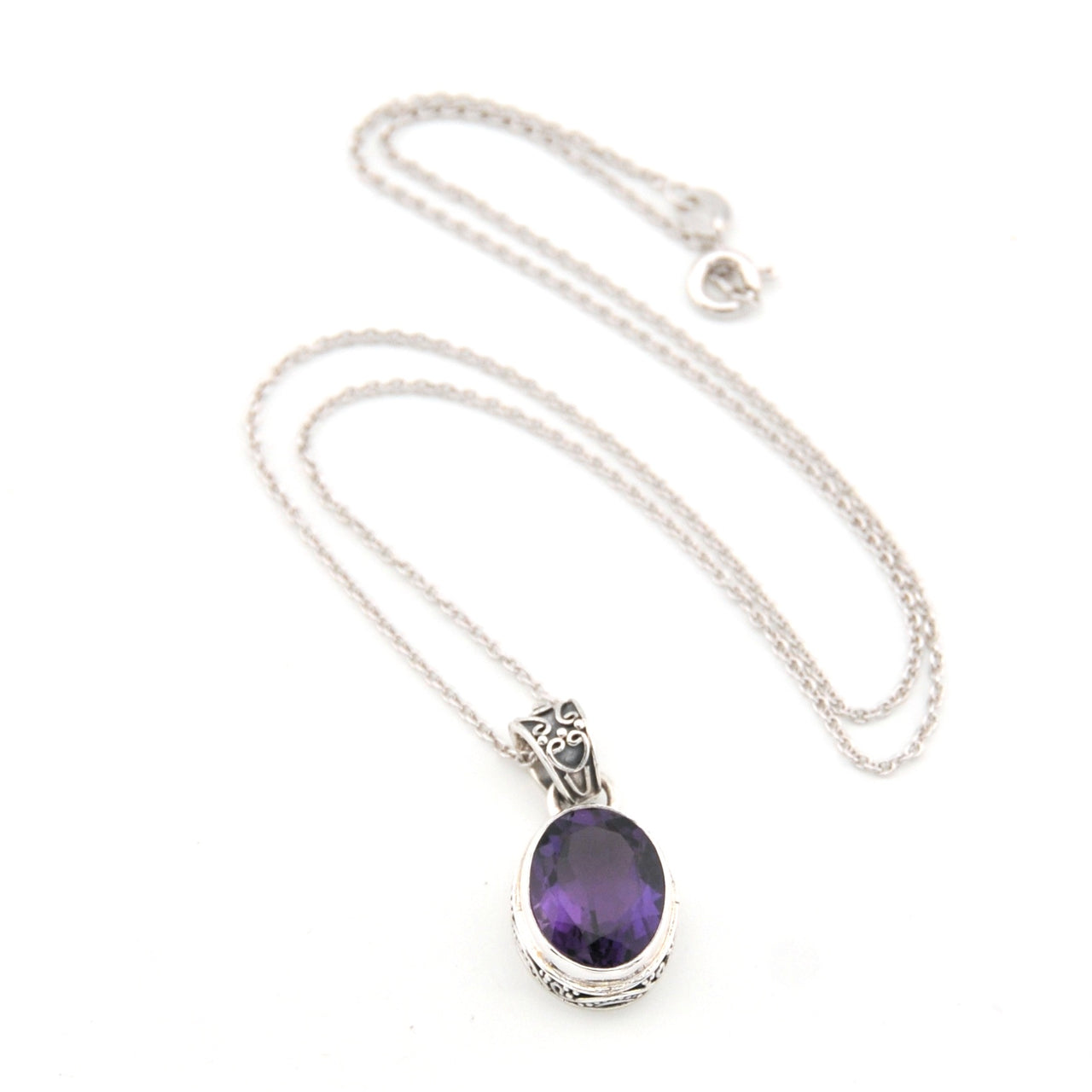 Silver necklace with a purple gemstone pendant on a white background