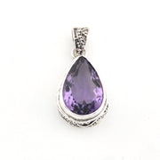 Purple teardrop pendant with silver setting on a white background