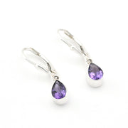 Silver earrings with purple teardrop gemstones on a white background