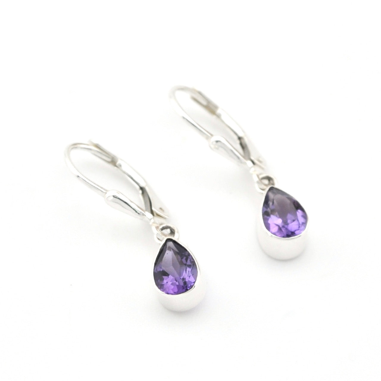 Silver earrings with purple teardrop gemstones on a white background