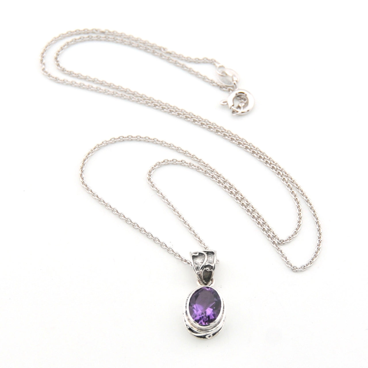 Silver necklace with a purple pendant on a white background