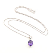 Silver necklace with a purple teardrop pendant on a white background