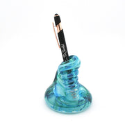 Blue glass pen holder with a black pen on a white background