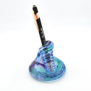 Blue glass pen holder with a black pen on a white background
