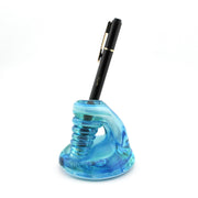Blue glass pen holder with a black pen on a white background
