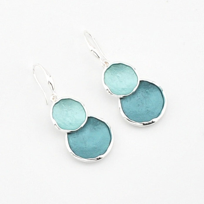 Pair of earrings with blue circular stones on a white background