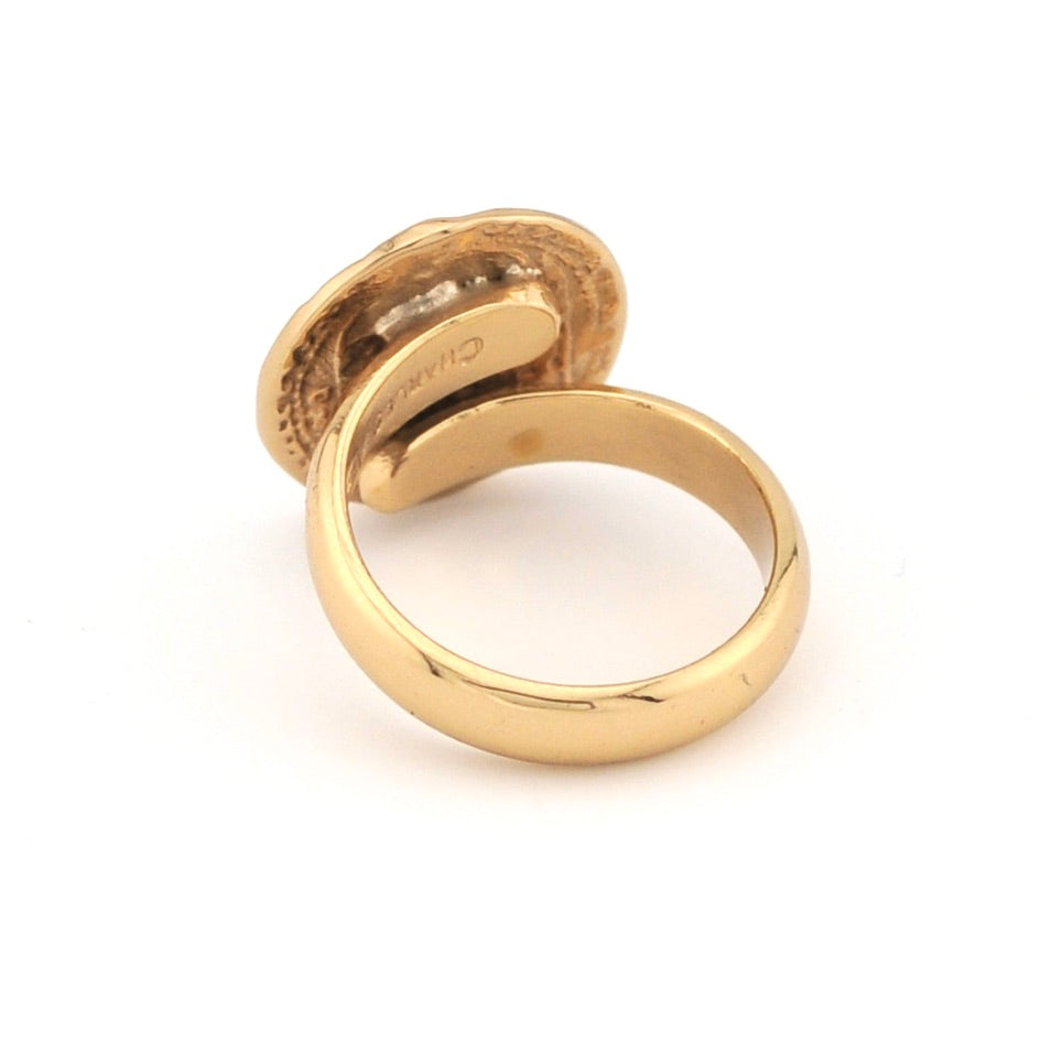 Gold ring with a visible brand logo on a white background