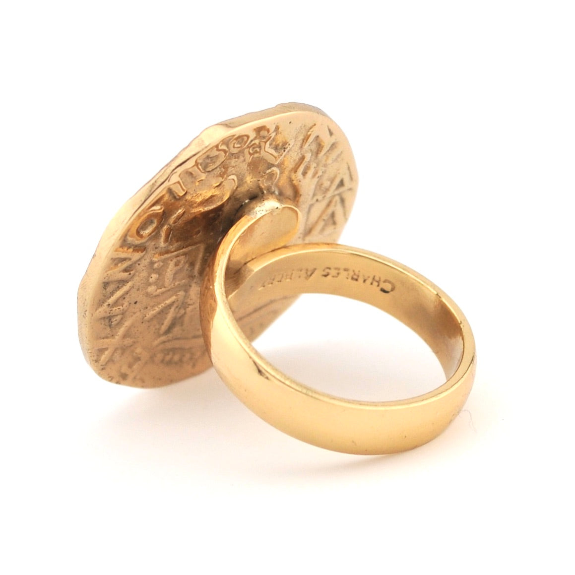 Gold ring with intricate design on a white background