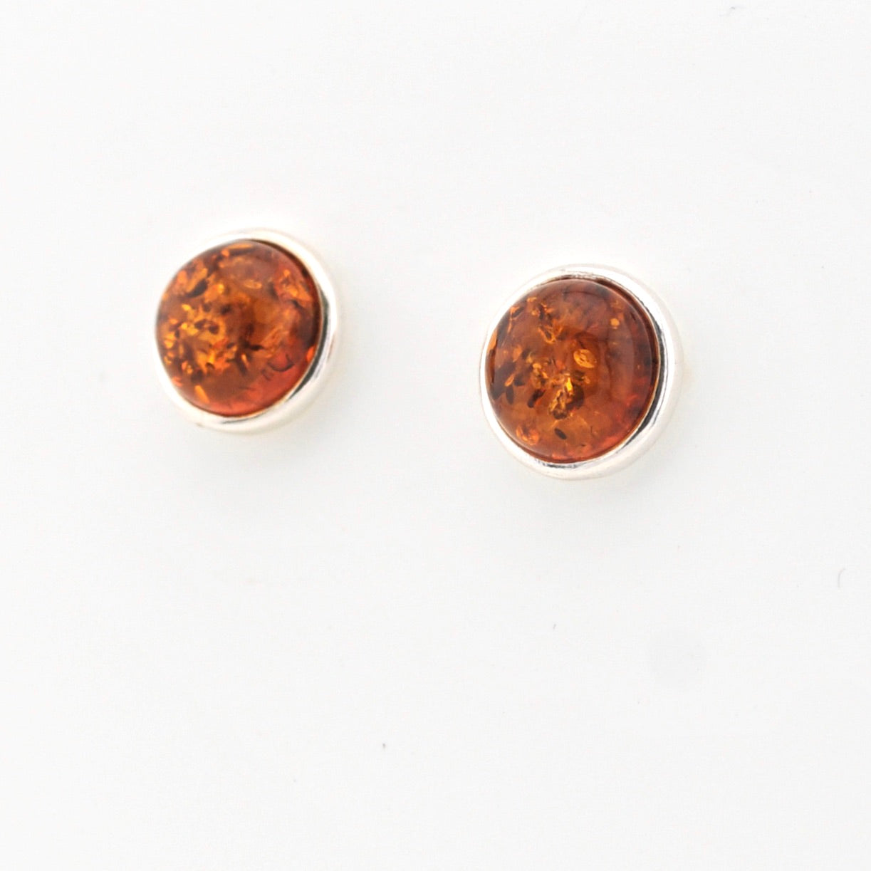 Pair of amber stud earrings on a white background
