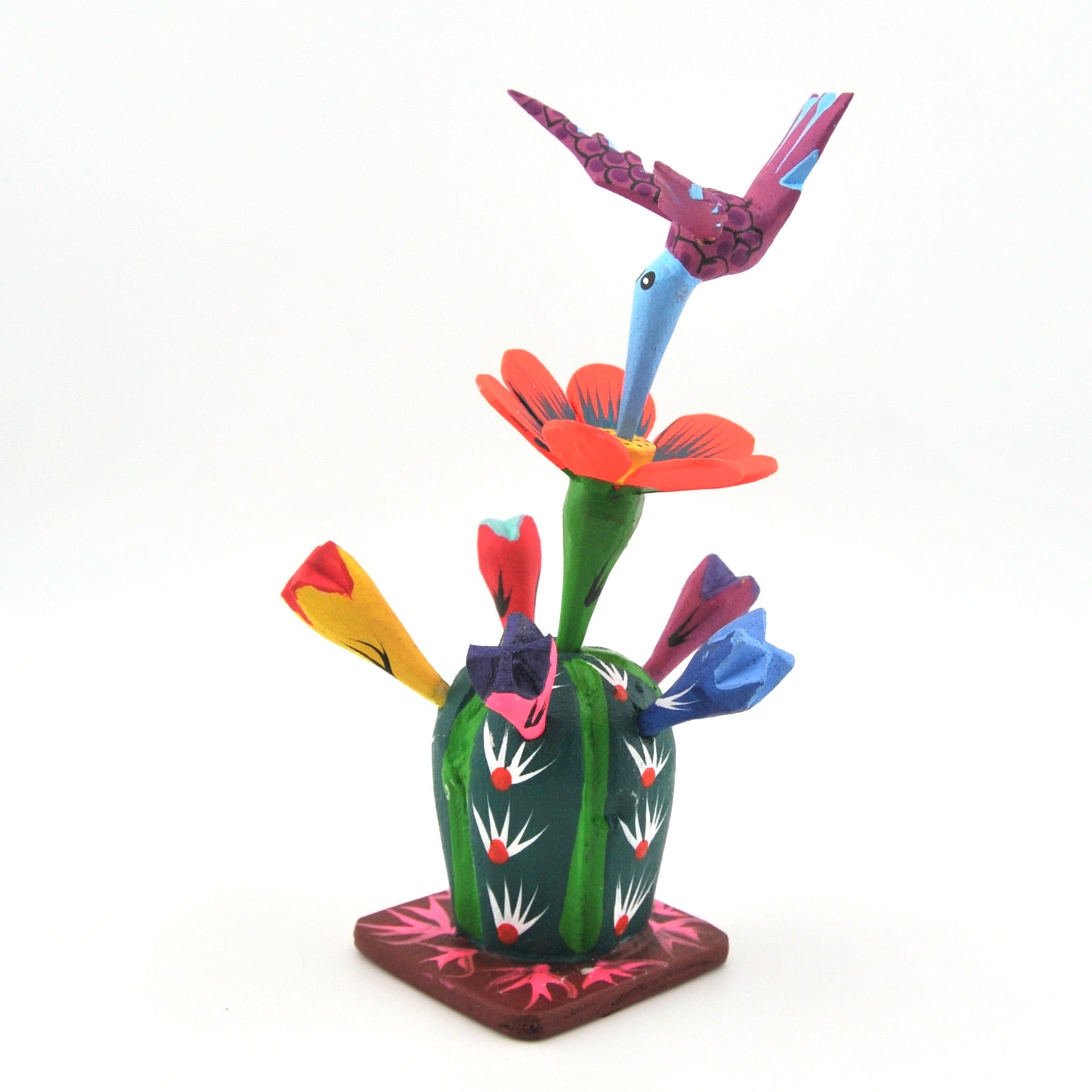 Colorful wood sculpture of a hummingbird and flowers on a white background