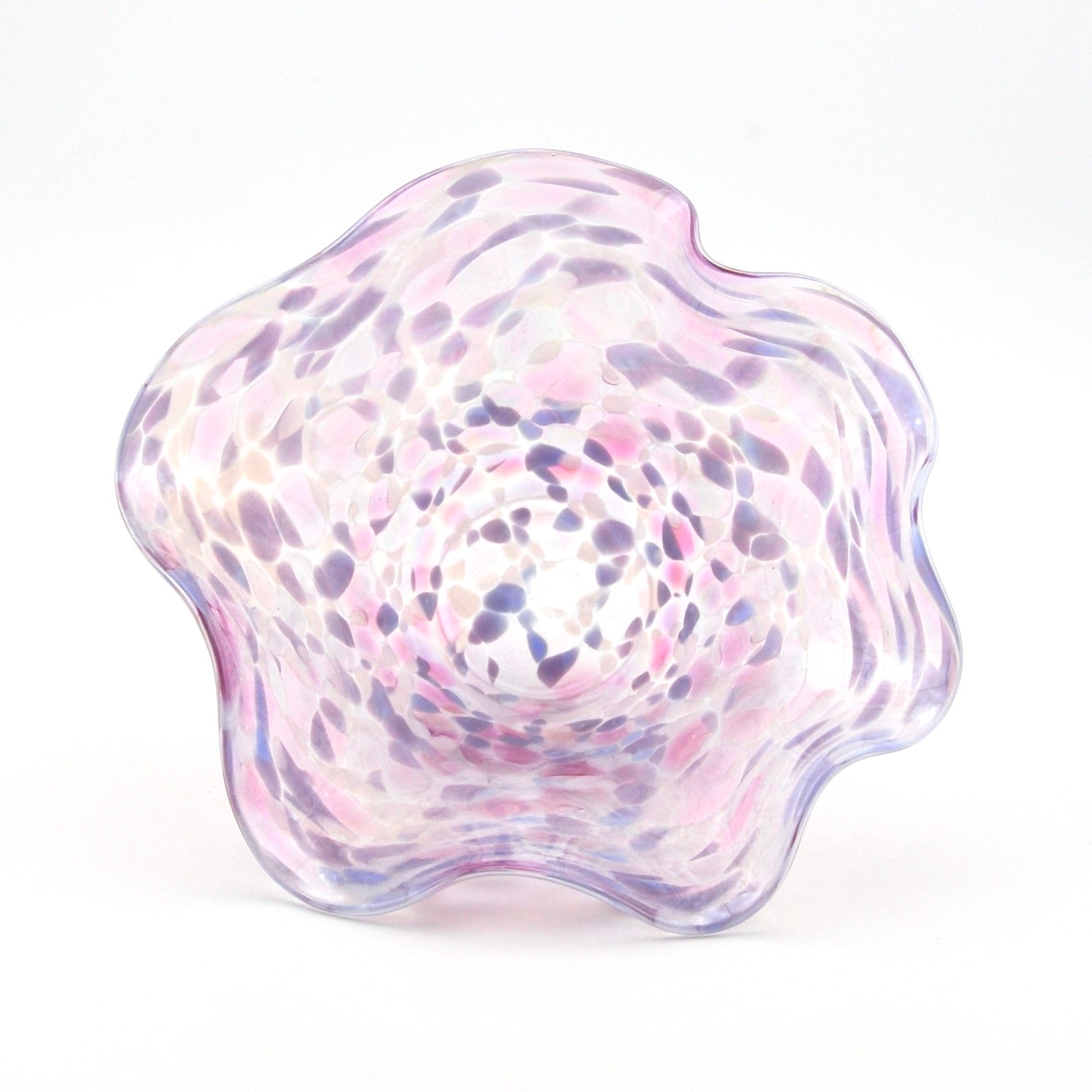 Glass bowl with a wavy design and purple and pink speckled pattern on a white background