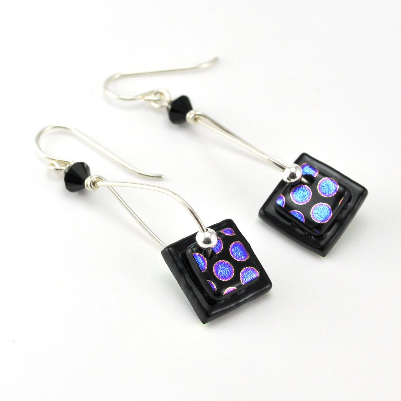 Pair of earrings with square black beads featuring colorful patterns on a white background
