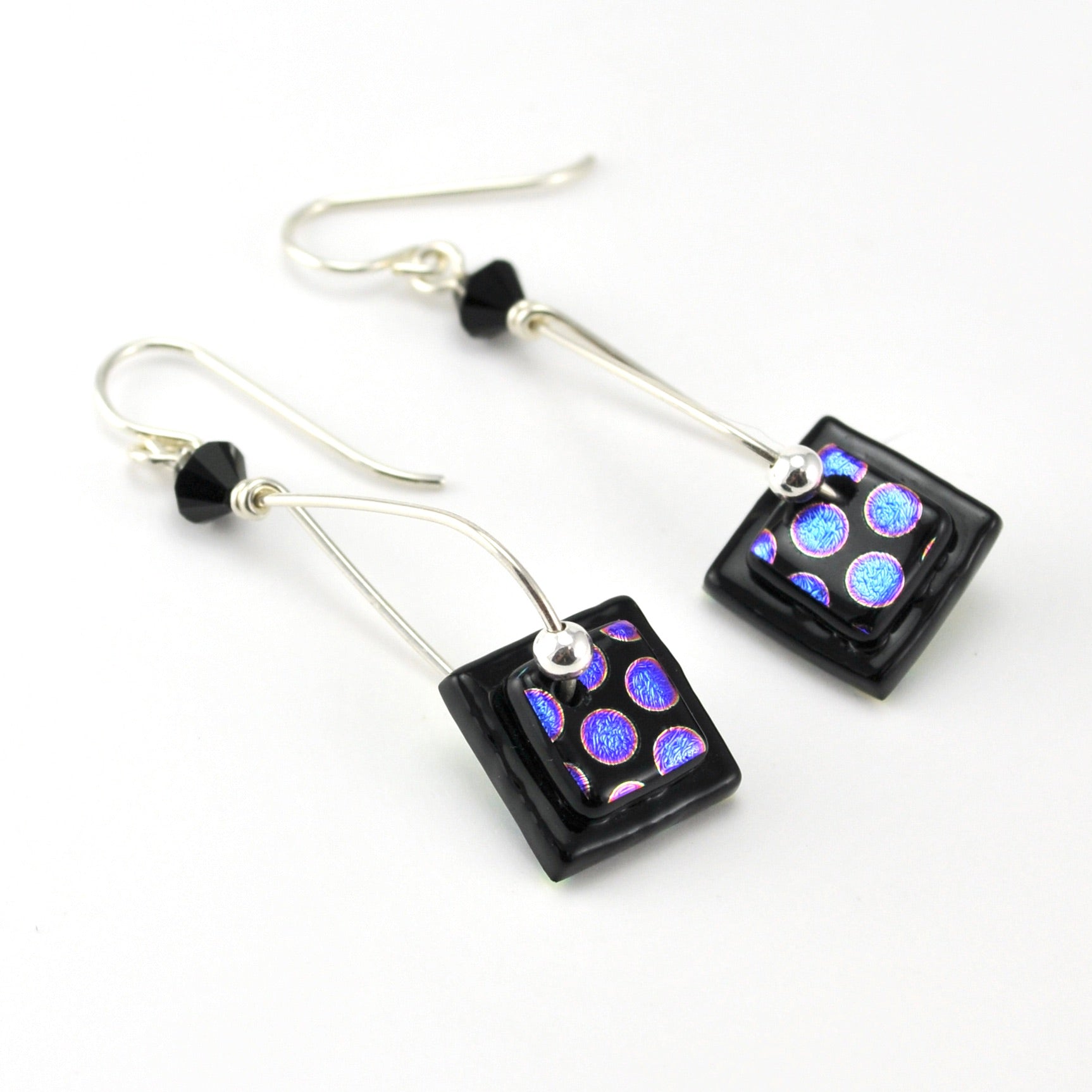 Pair of earrings with square black beads featuring colorful patterns on a white background