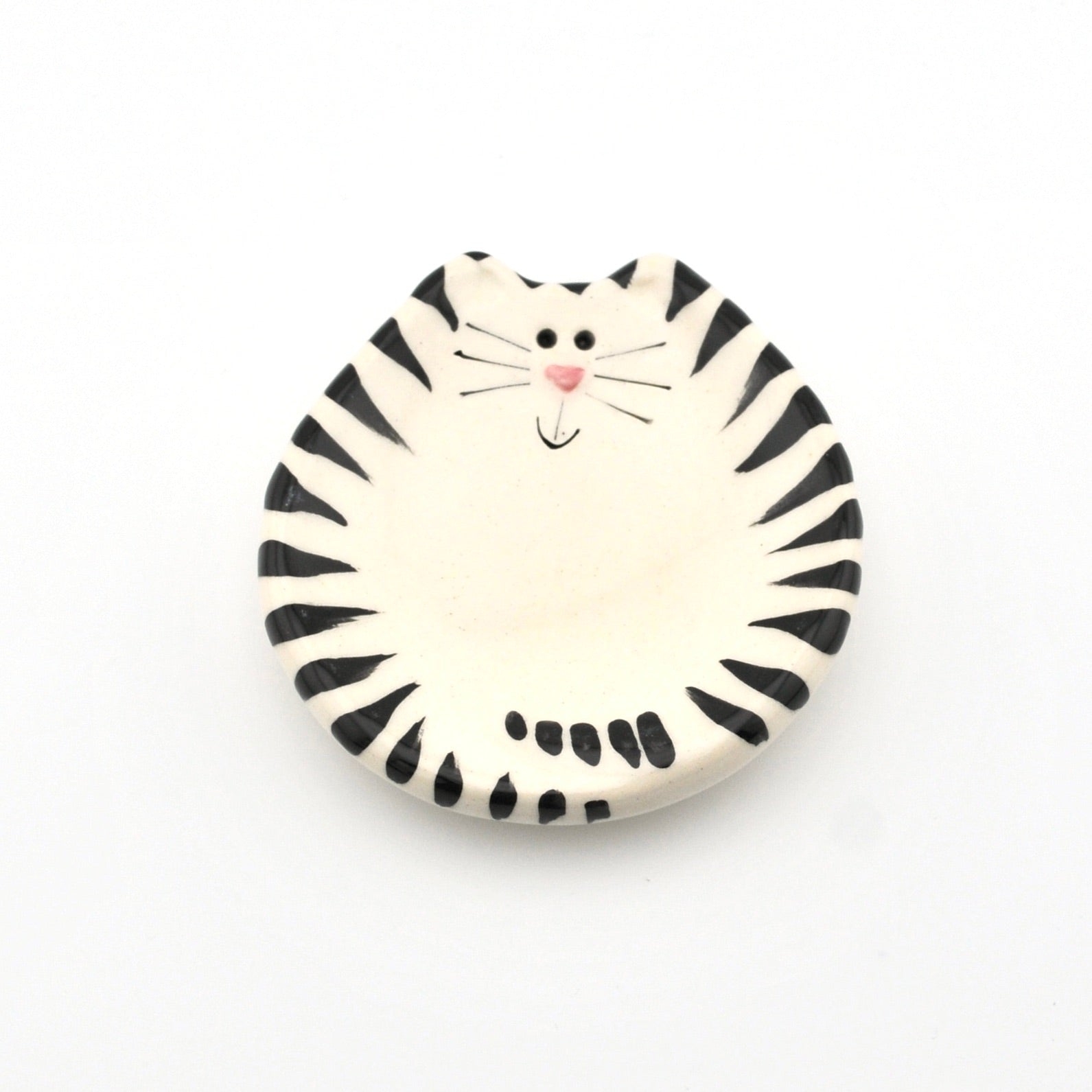 Round ceramic dish with a black and white striped cat design on a white background