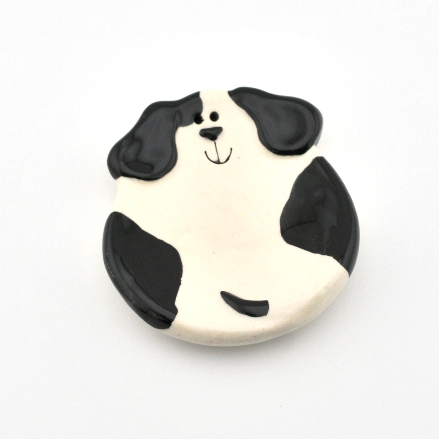 Dog-shaped dish with black and white design on a white background