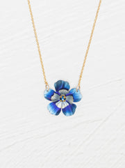 Blue flower-shaped pendant on a gold chain against a white background
