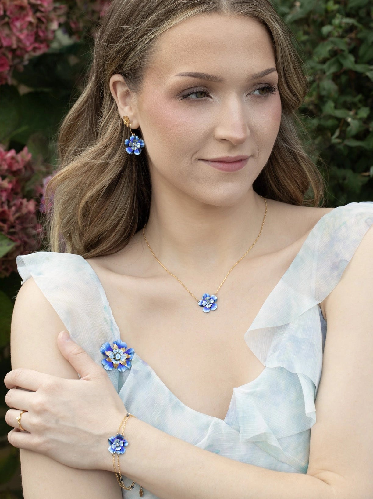 Woman wearing blue floral jewelry set outdoors