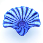 A blue and white striped glass bowl with a scalloped rim, photographed from directly above on a white background.