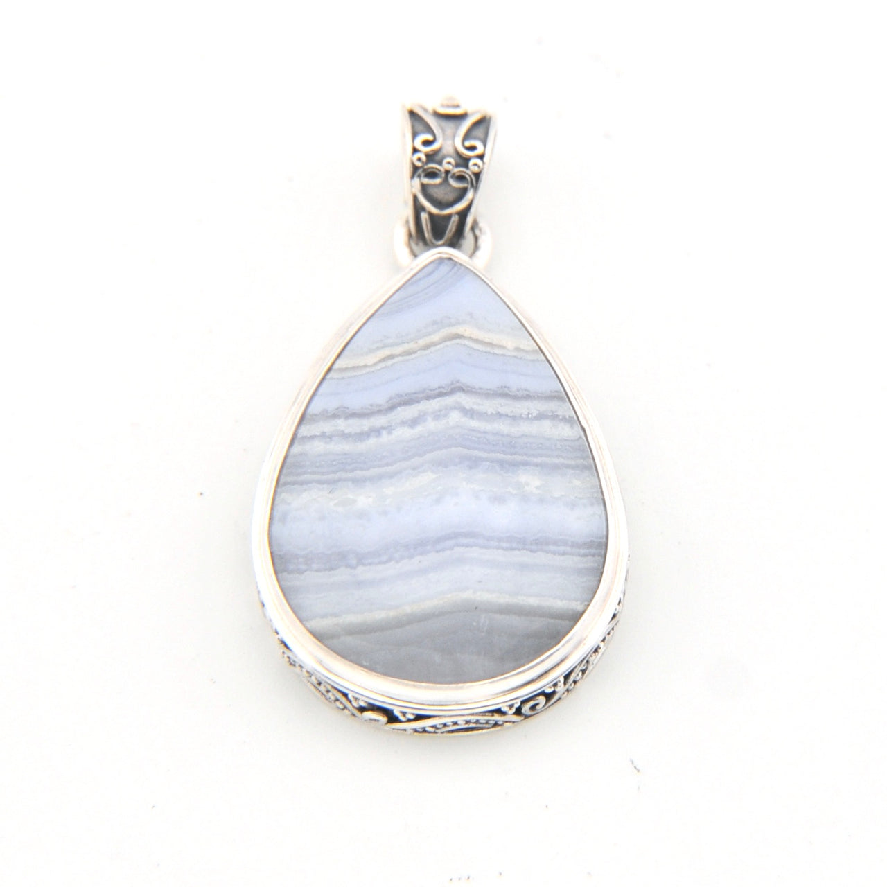 Teardrop-shaped pendant with blue pattern and silver frame on a white background