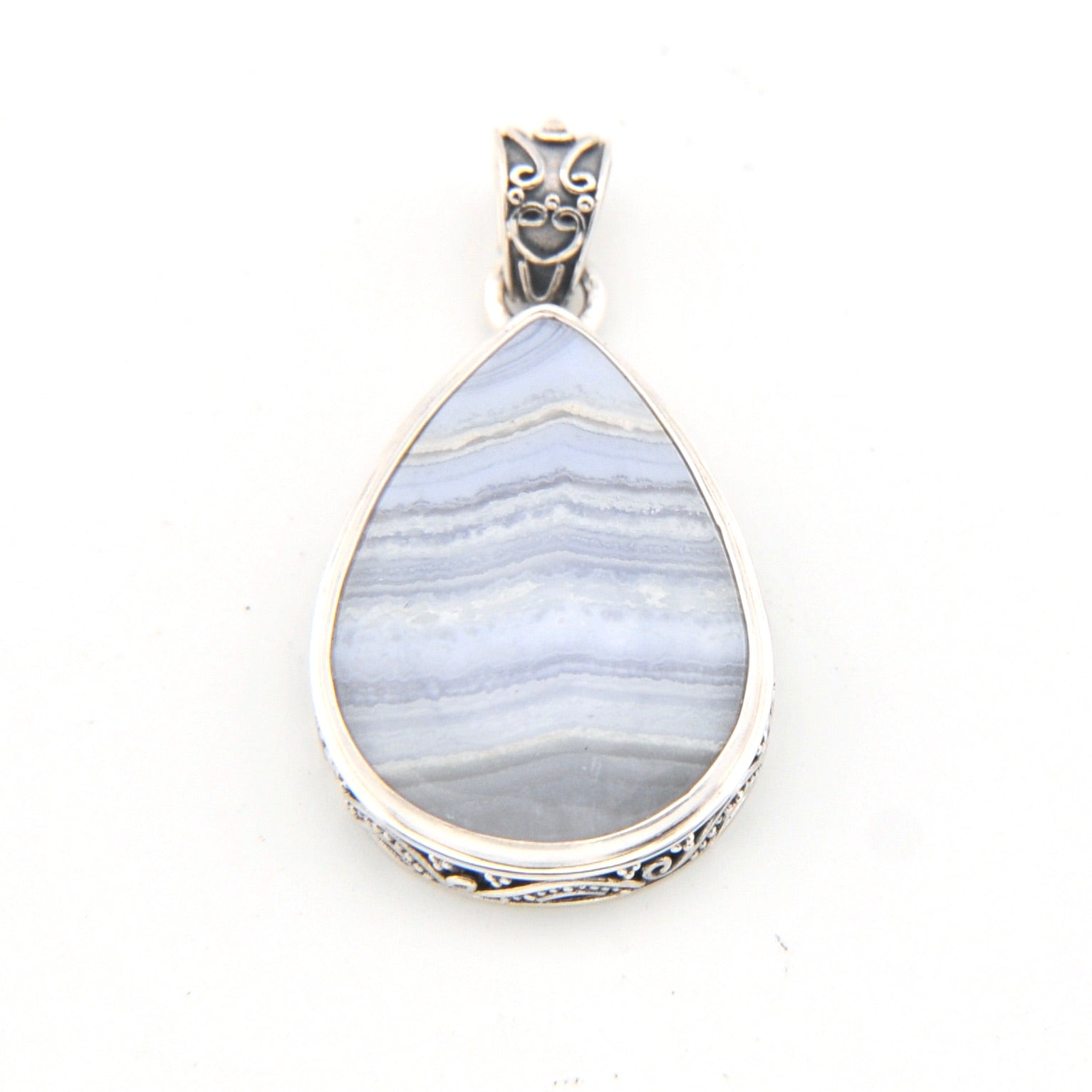 Teardrop-shaped pendant with blue pattern and silver frame on a white background