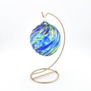 Decorative glass ornament with blue and green swirls on a white background