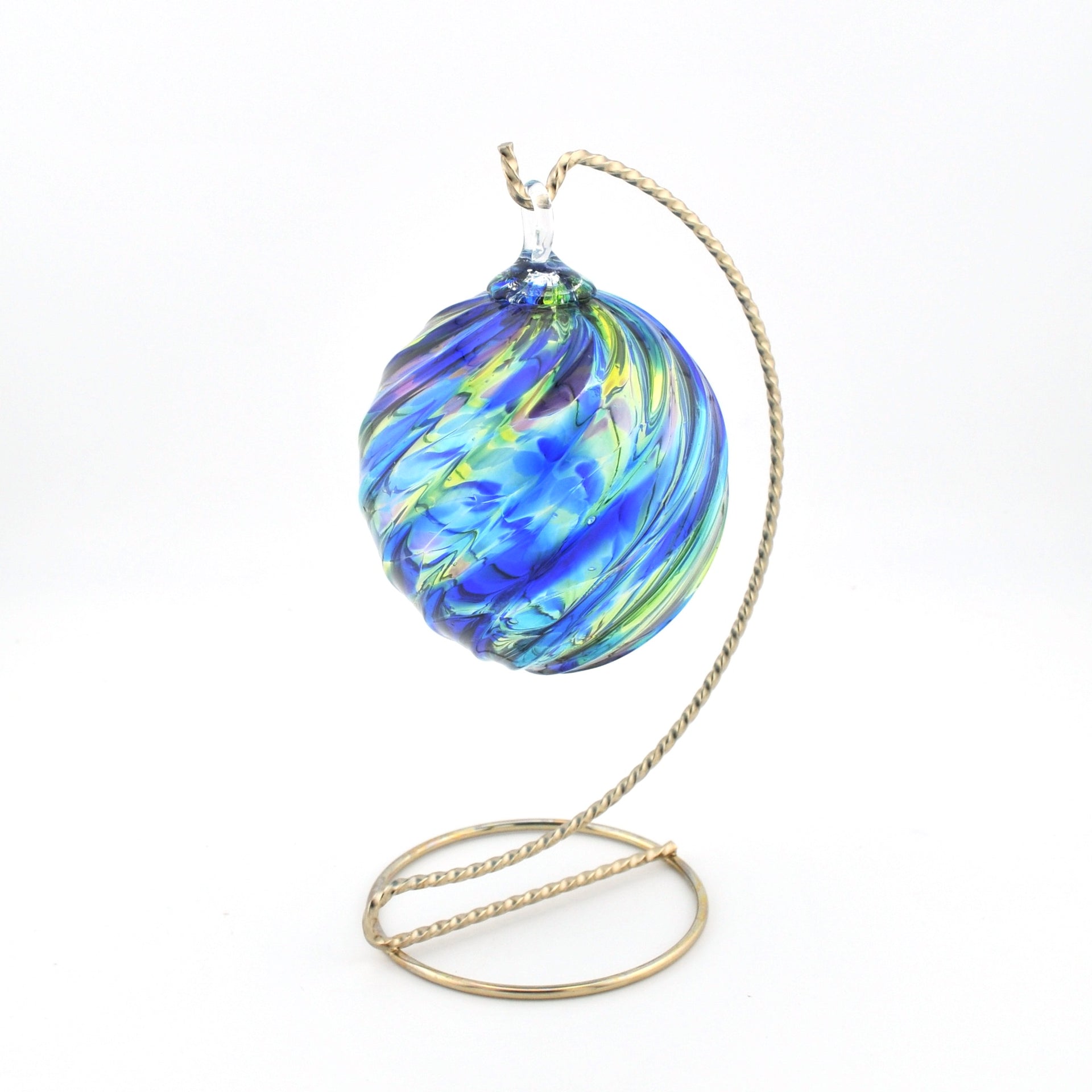Decorative glass ornament with blue and green swirls on a white background