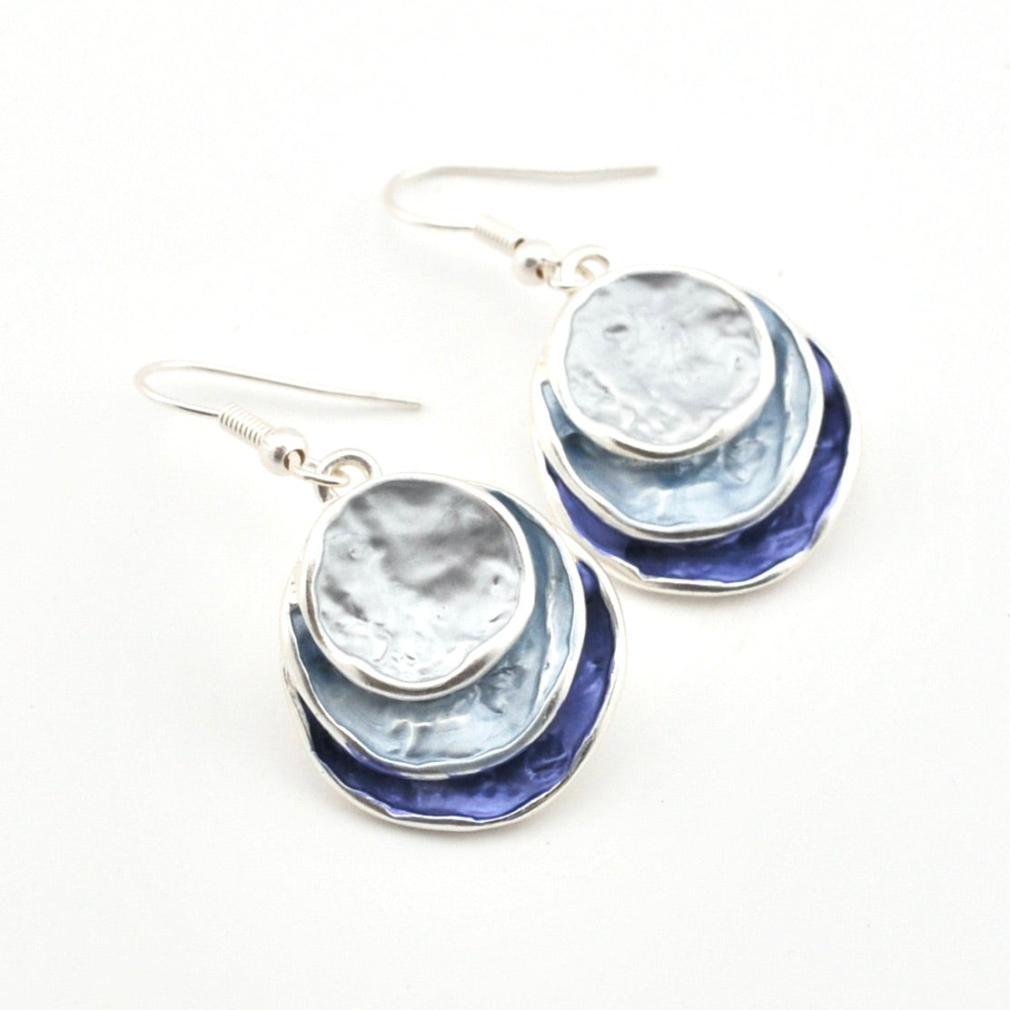 Pair of earrings with blue and silver layered design on a white background