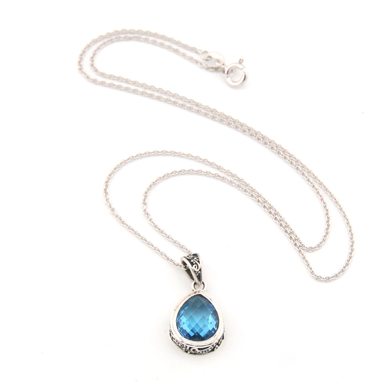 Silver necklace with a blue teardrop pendant on a white background